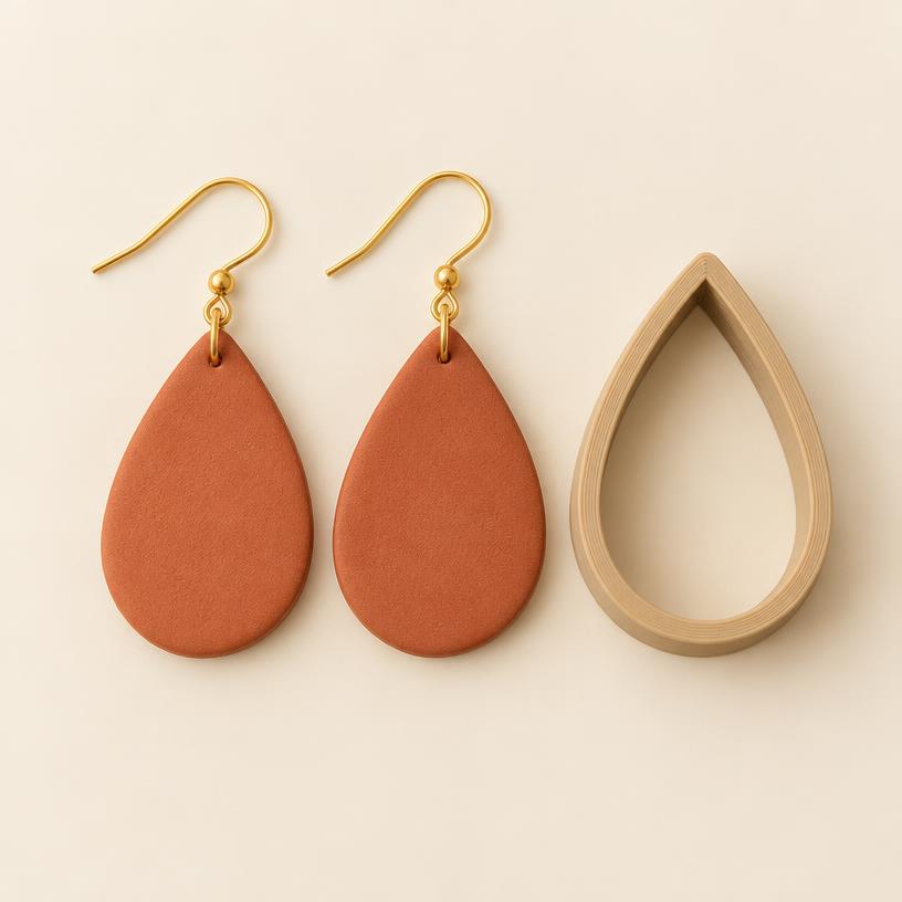 Teardrop clay earrings beside their matching cutter